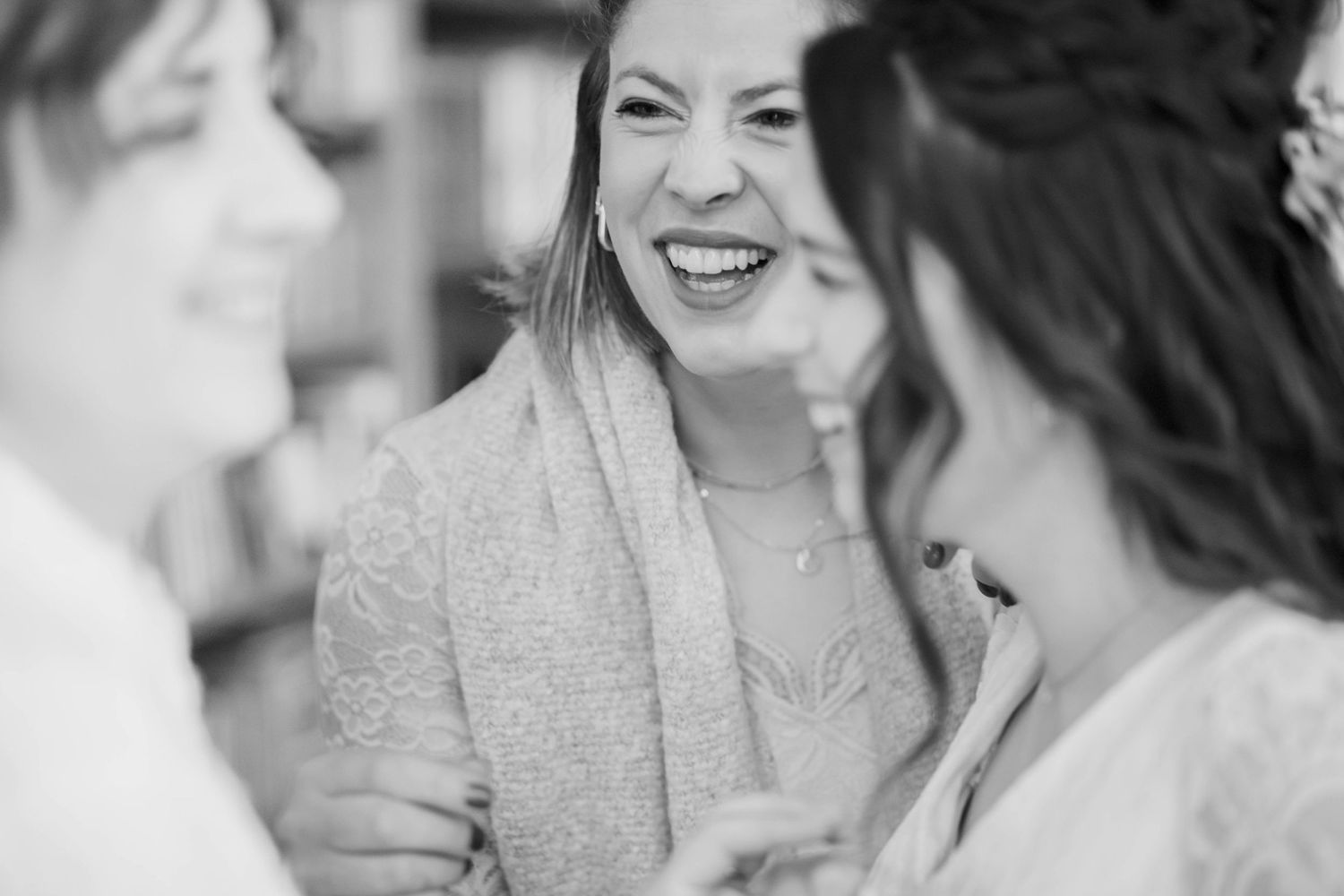 Black and white candid photo of people laughing during a joyful moment.