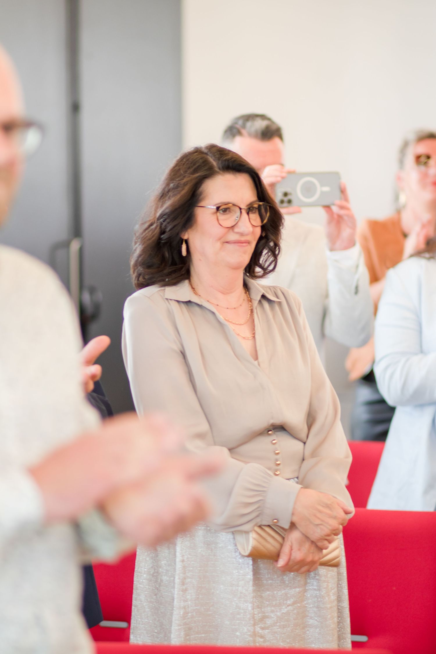 Wedding guest in beige dress shows excitement during ceremony celebration.