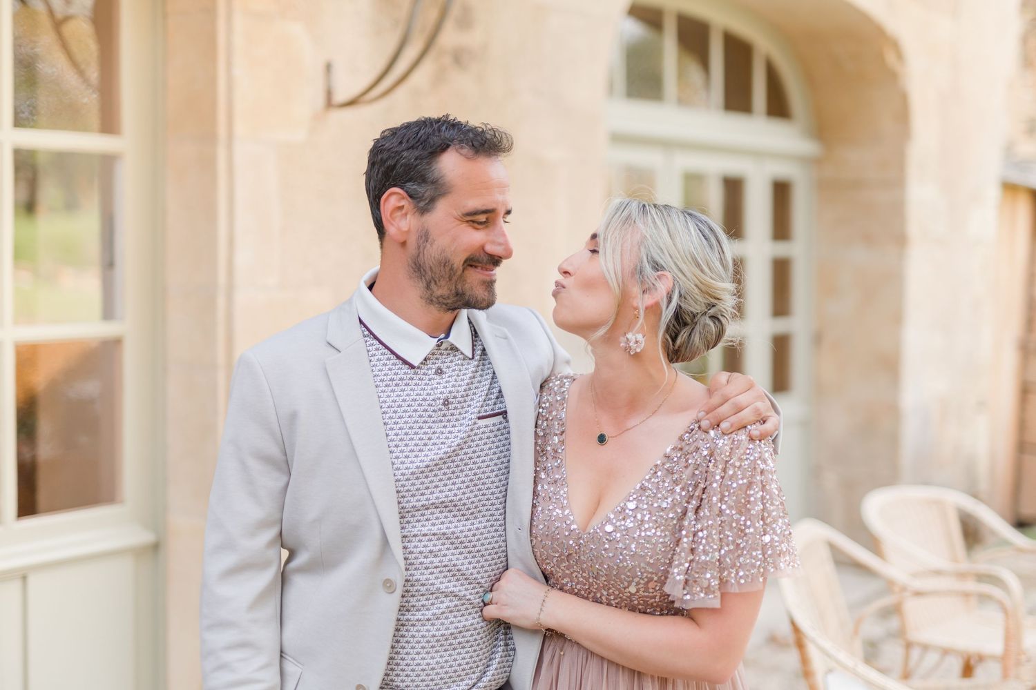 Happy couple sharing a romantic moment under an elegant stone archway.