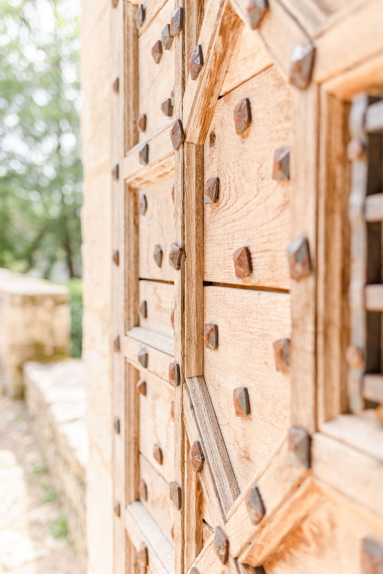 Close-up of antique wooden door with decorative metal studs and hardware.