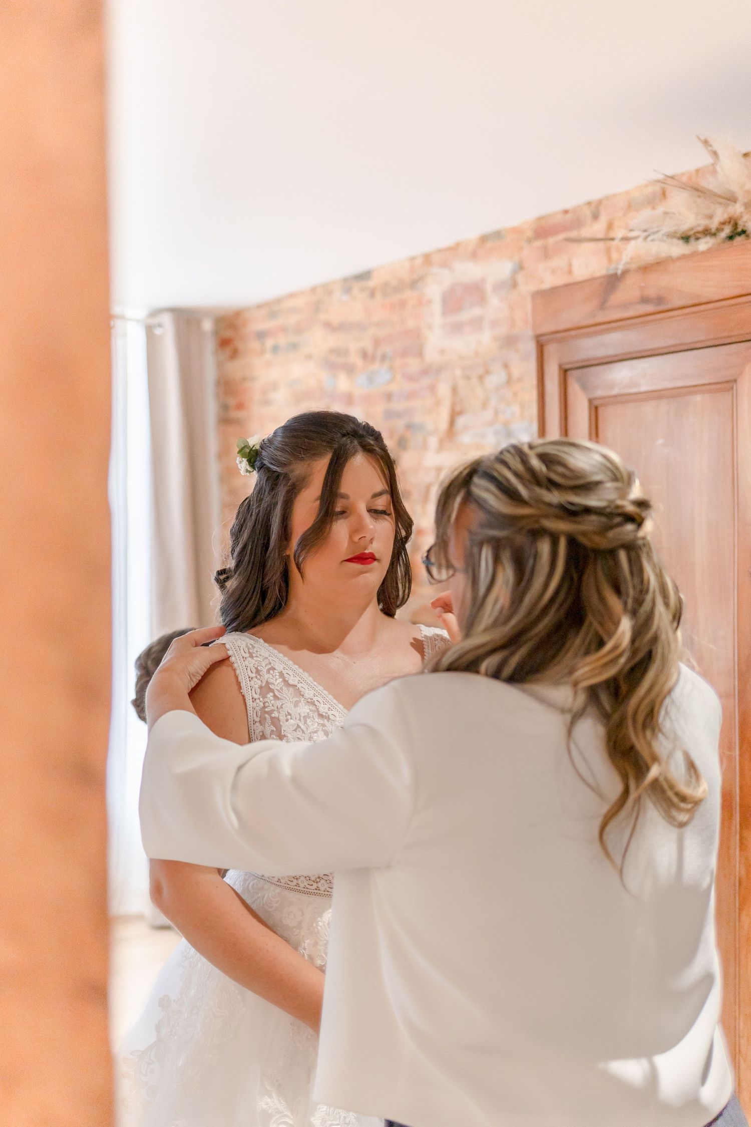 Candid moment of laughter and joy during wedding dress preparations.