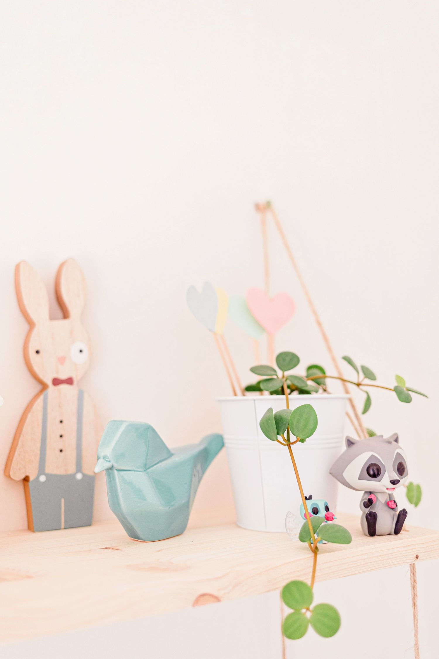Minimalist shelf display featuring wooden bunny decor and potted plants.