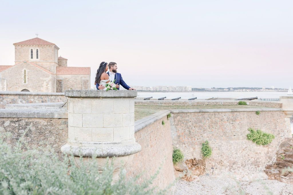 Historic stone architecture with a church building perched on coastal fortifications at sunset.