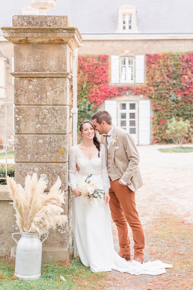 Romantic wedding portrait series against stone pillars and autumn walls with pampas grass decor.