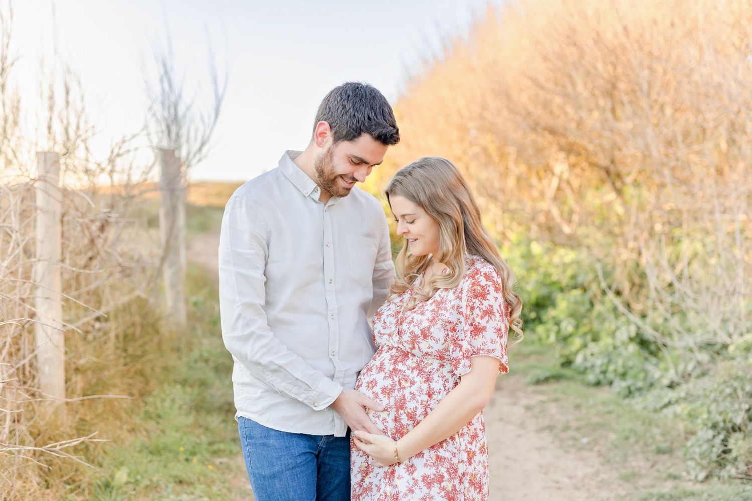 A couple walking together on a nature path during golden hour.