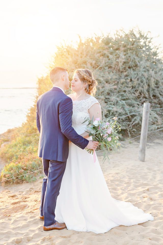 Wedding couple sharing an intimate moment on a beach during golden hour.
