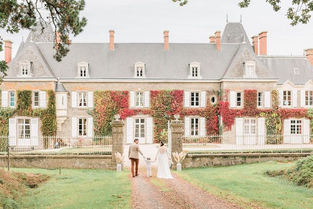 Charming French countryside manor with red ivy climbing the stone walls.