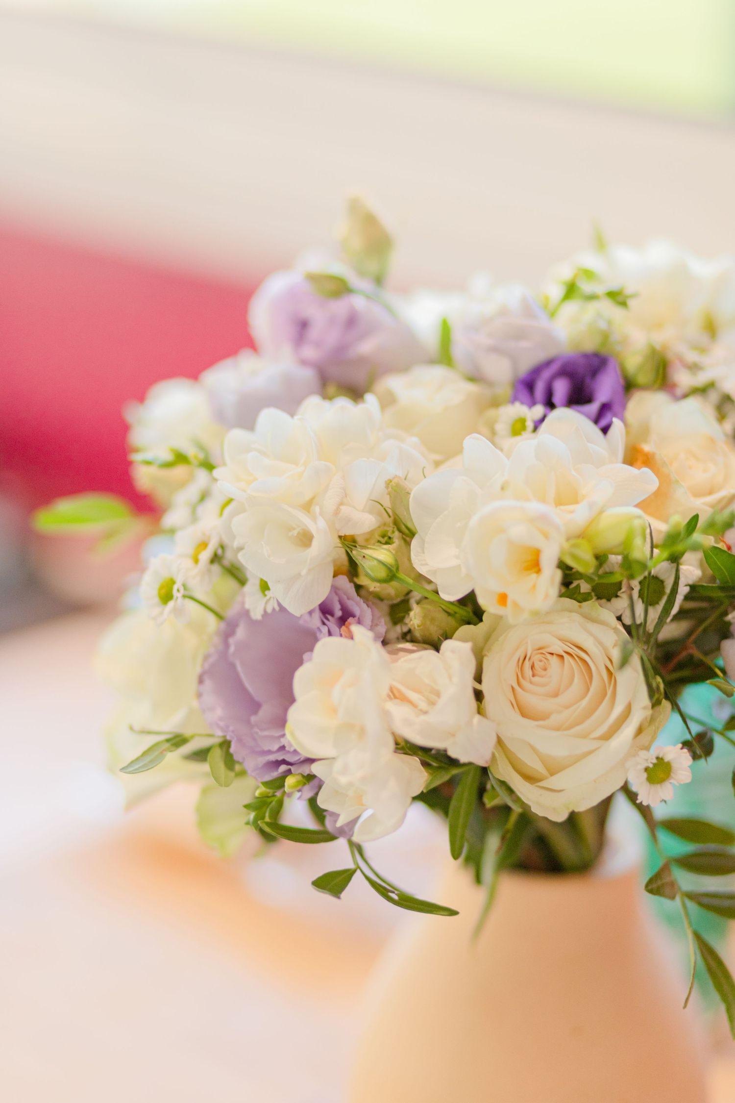 Elegant floral arrangement with white roses and purple blooms in soft focus.