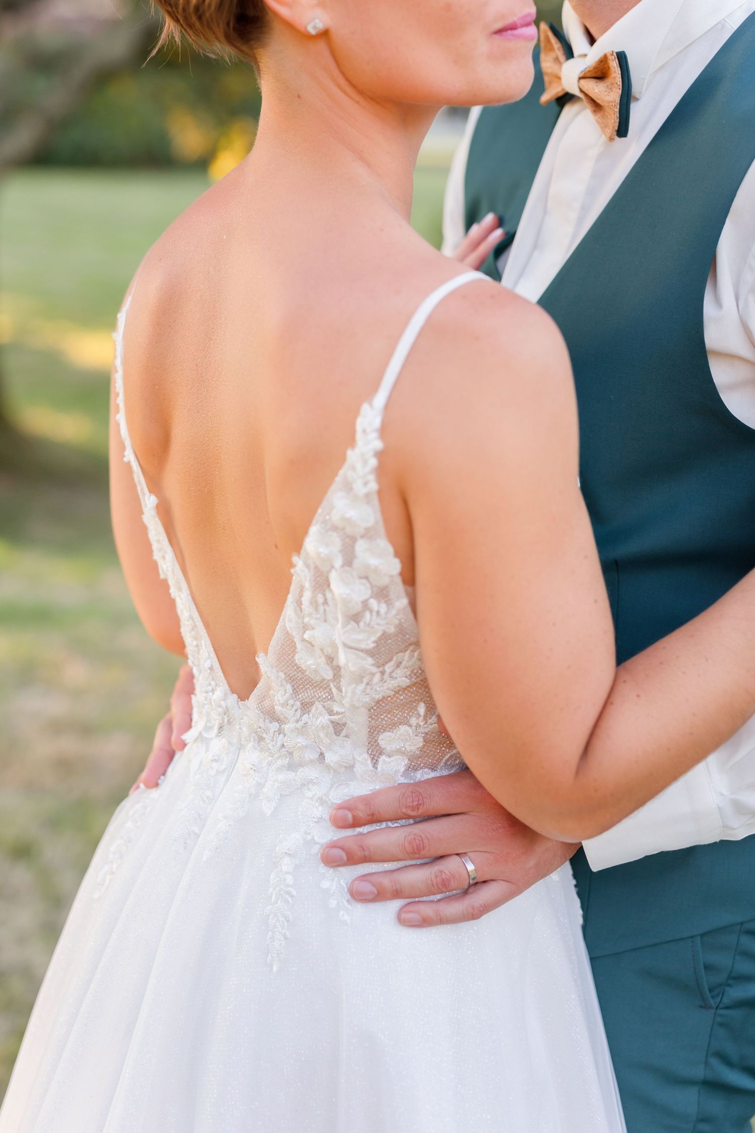 Close-up detail shot of wedding dress showing intricate lace bodice and back design.