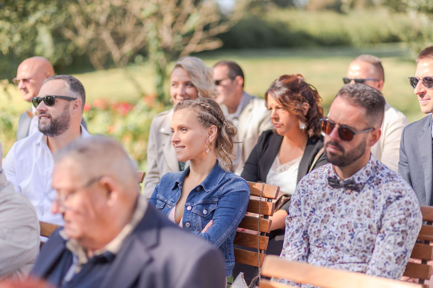 Wedding guests seated in rows during outdoor ceremony.