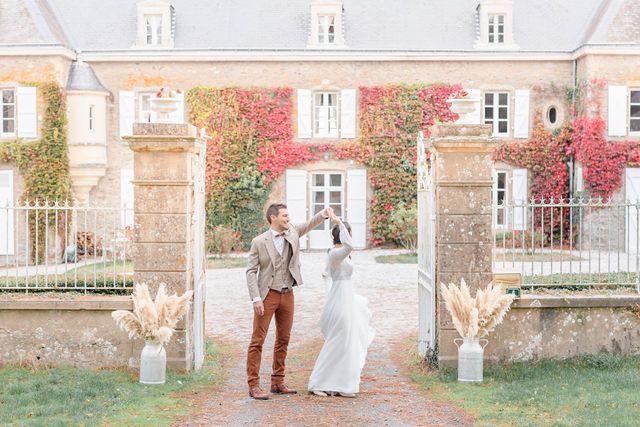 Soft pastel wedding photos showing couple along stone mansion with climbing red ivy.