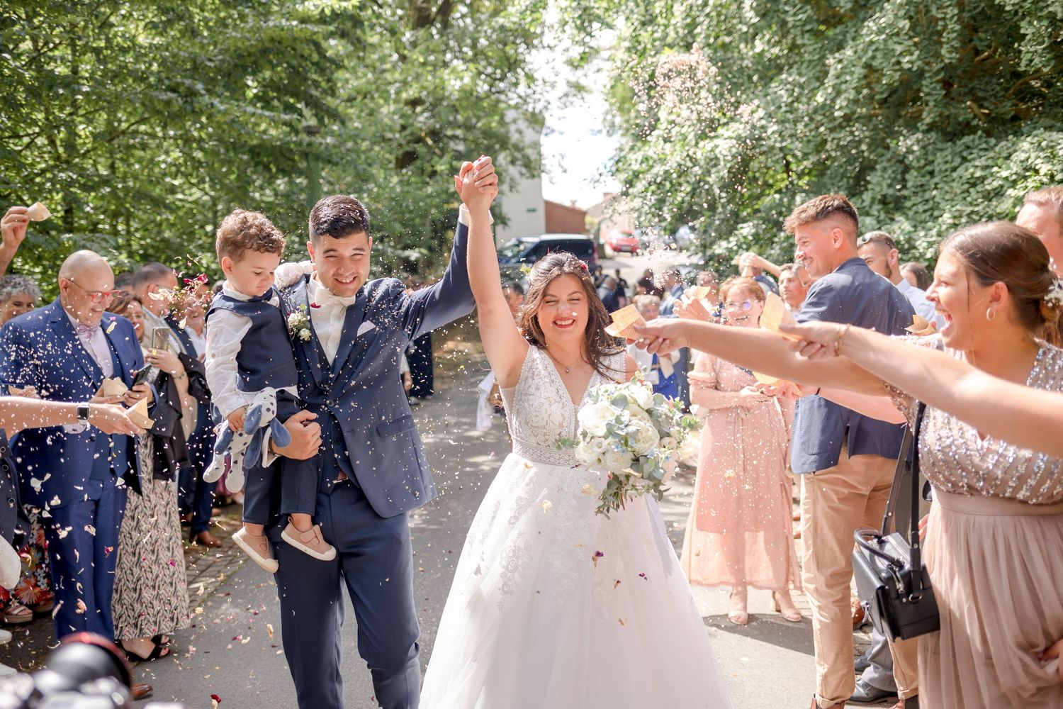 Wedding celebration candid moments captured on tree-lined pathway.