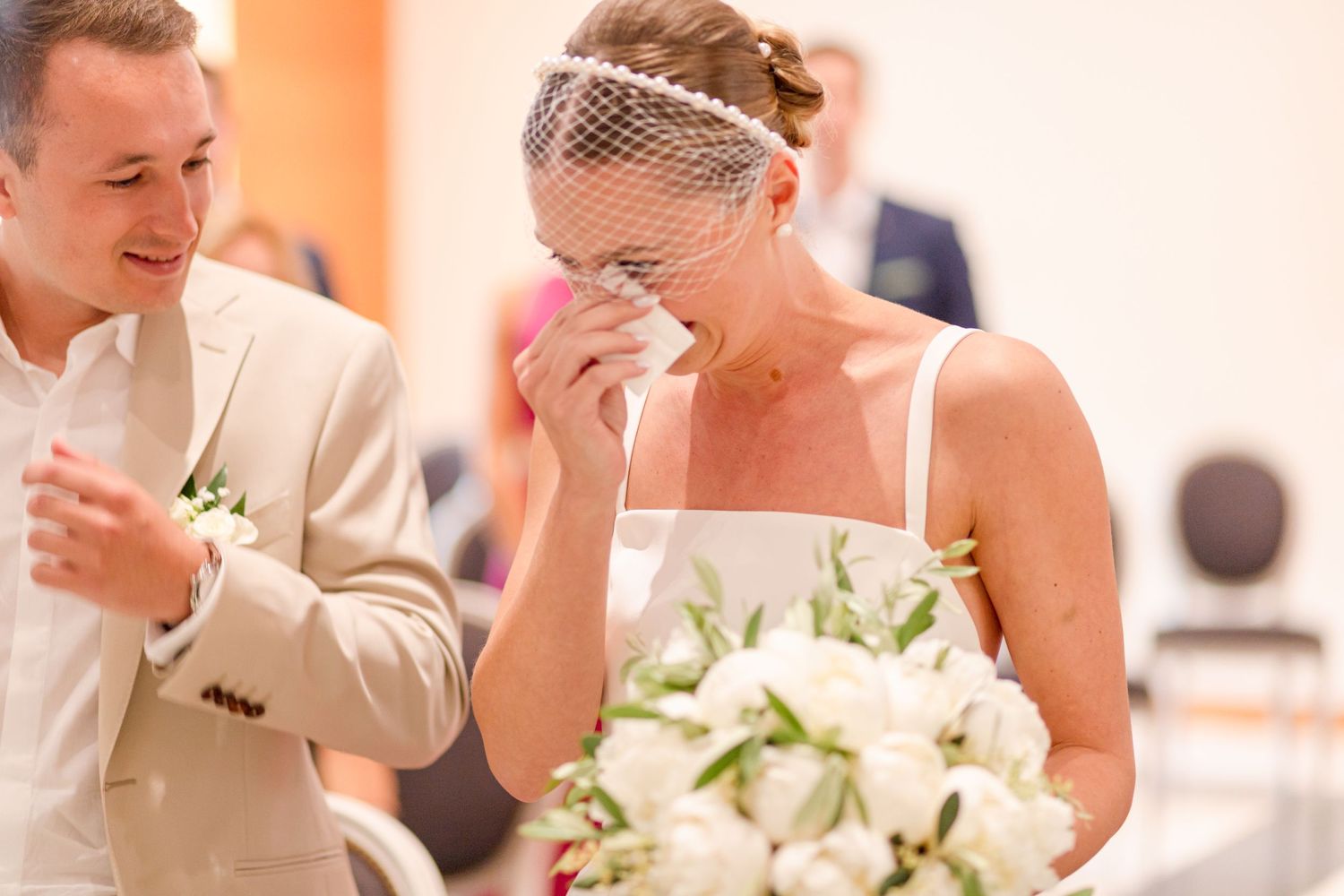 Wedding reception celebration with white floral centerpieces and elegant table settings.