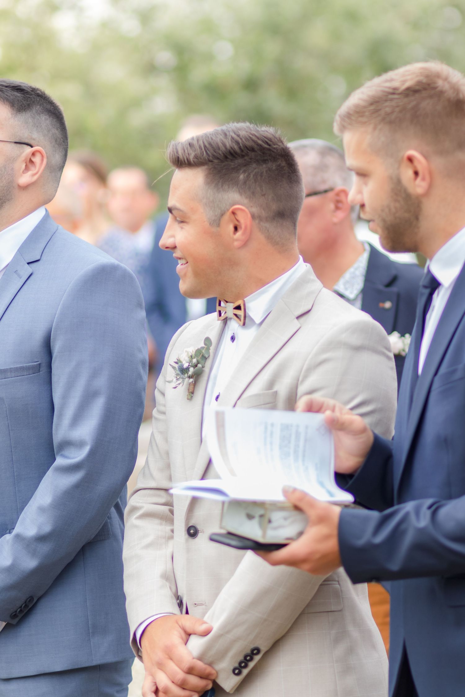 Groomsmen in suits share a candid moment before the wedding ceremony.