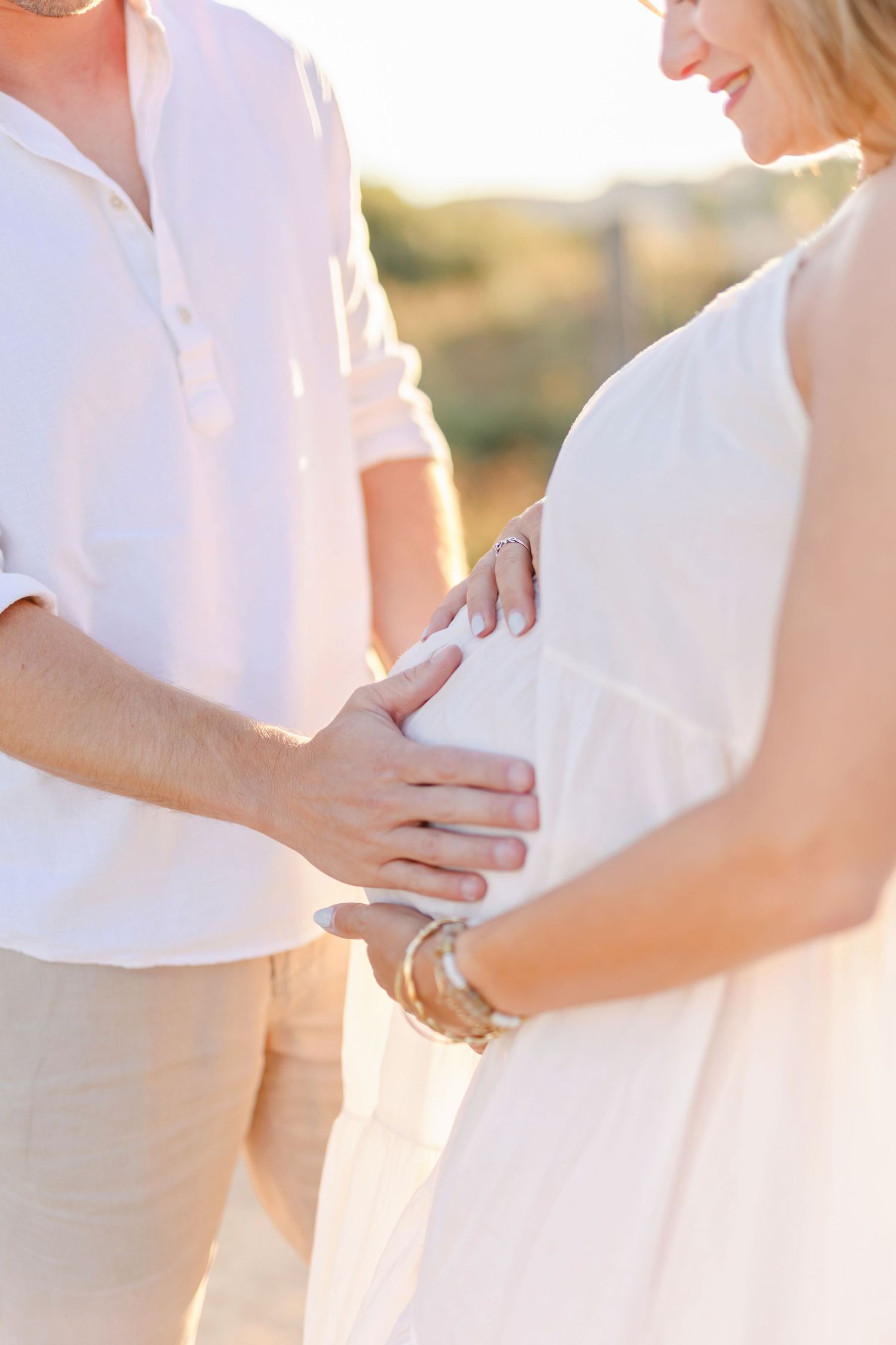 Series of intimate maternity photos showing hands on pregnant belly in warm sunlight.
