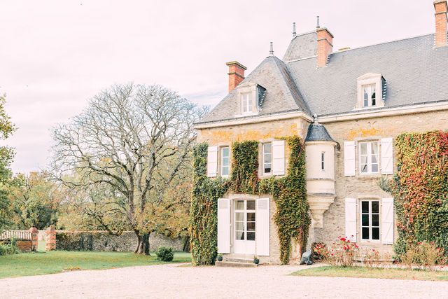 French chateau style building with classic architecture photographed in soft pastel tones.