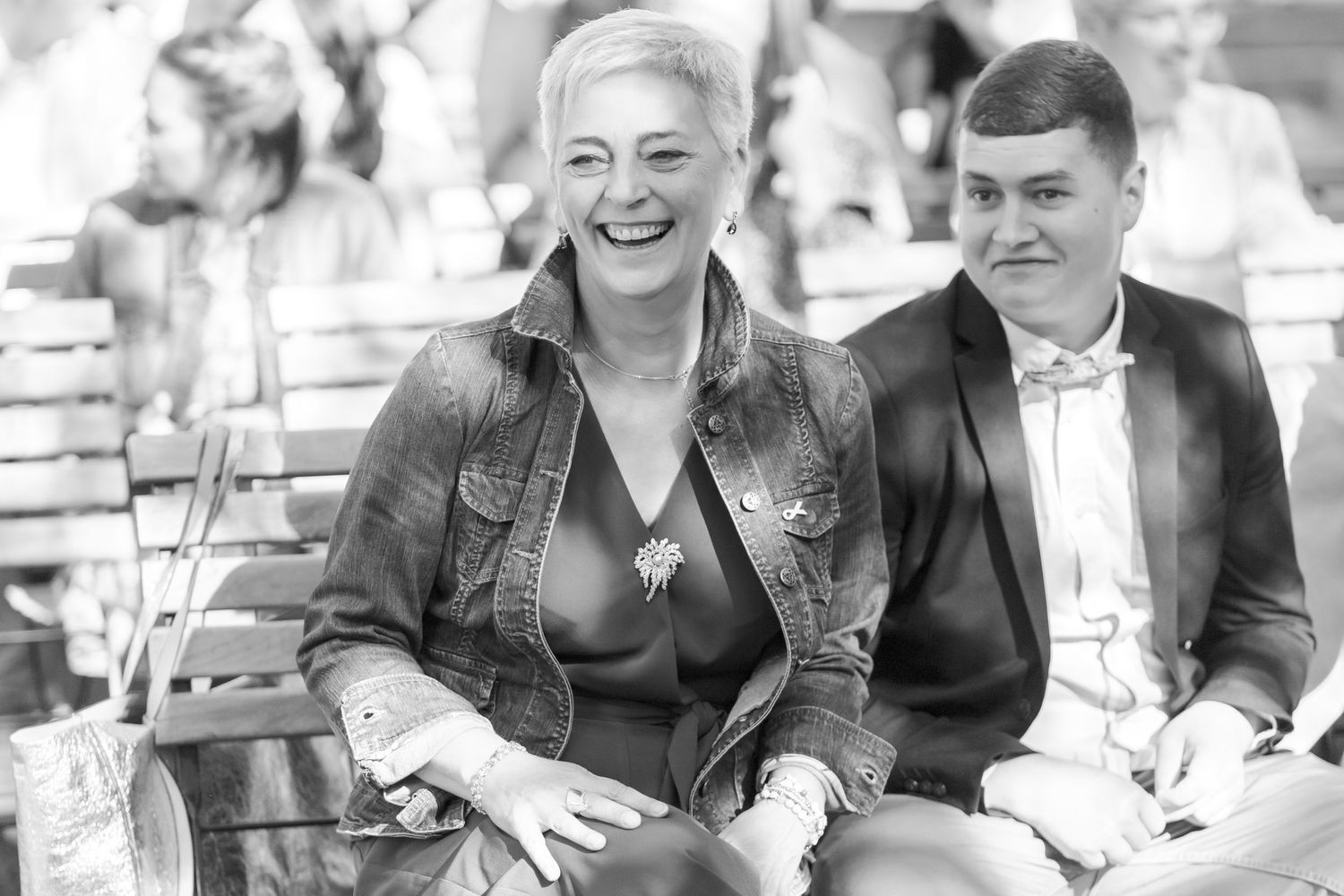 Black and white vintage style photo of wedding guests seated outdoors.