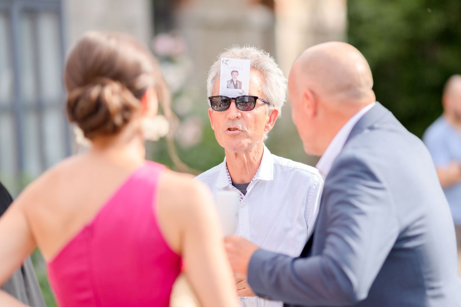 Wedding party mingles during outdoor reception at elegant venue.