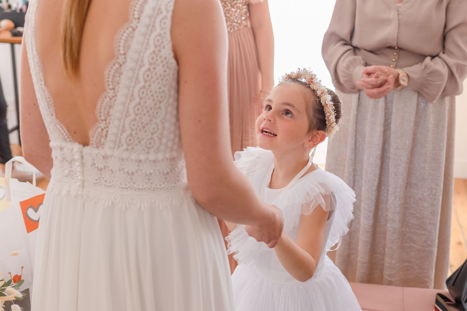 White wedding dress detail with young attendant looking up adoringly.