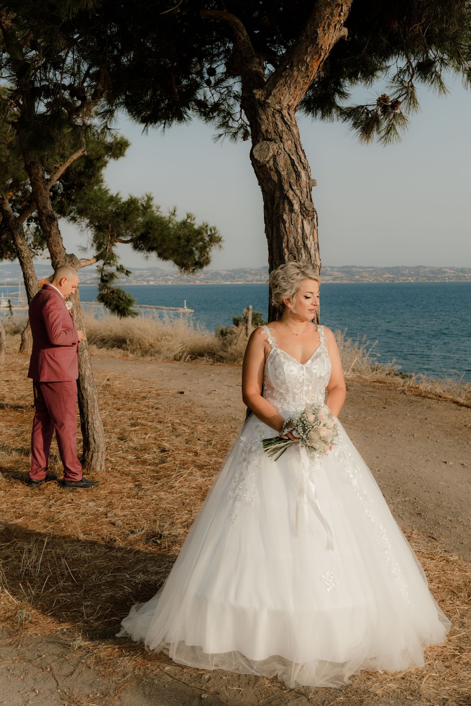Seaside wedding photos featuring a bride in a flowing white ballgown dress.