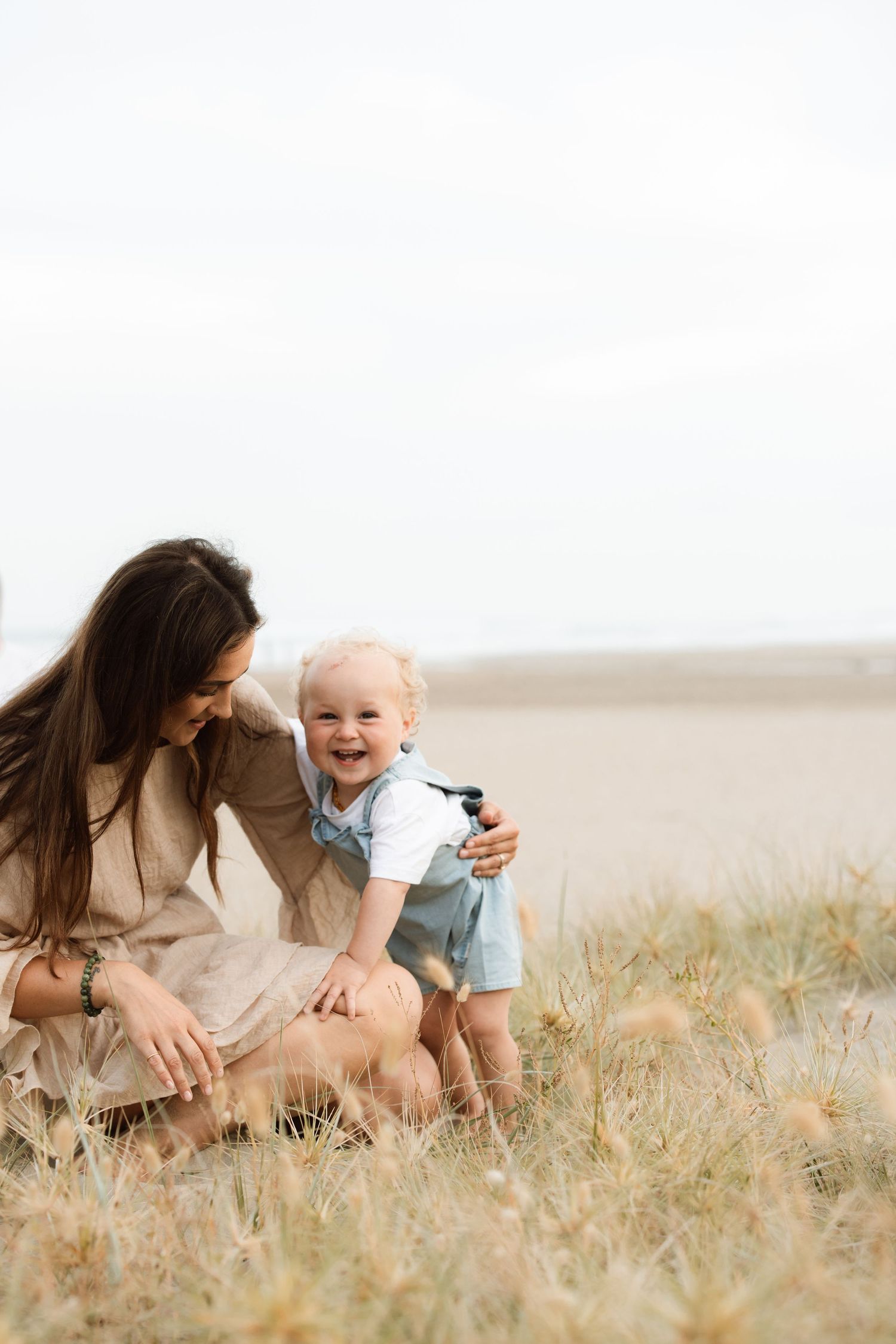 A tender moment between parent and child unfolds as they play together in a golden wheat field on a sunny day.