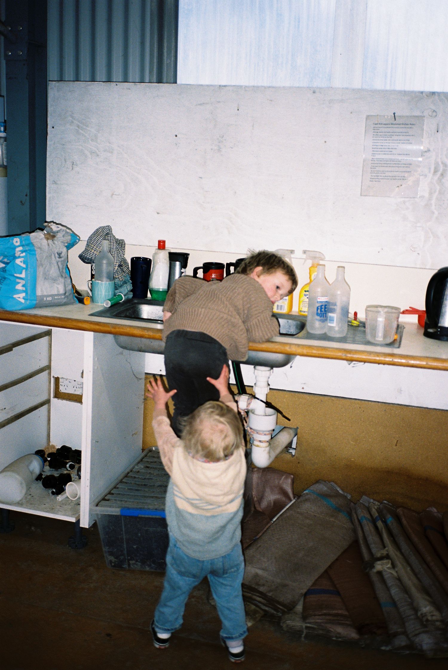 A series of photos showing someone in jeans crawling into what appears to be a basement or storage space.