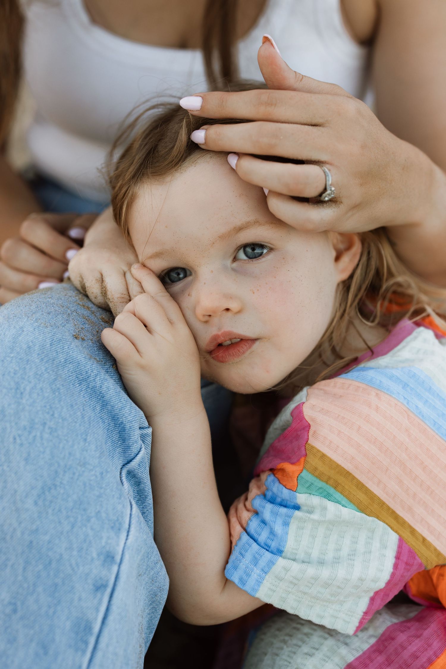 Tender moment of comfort and connection with colorful patchwork blanket.