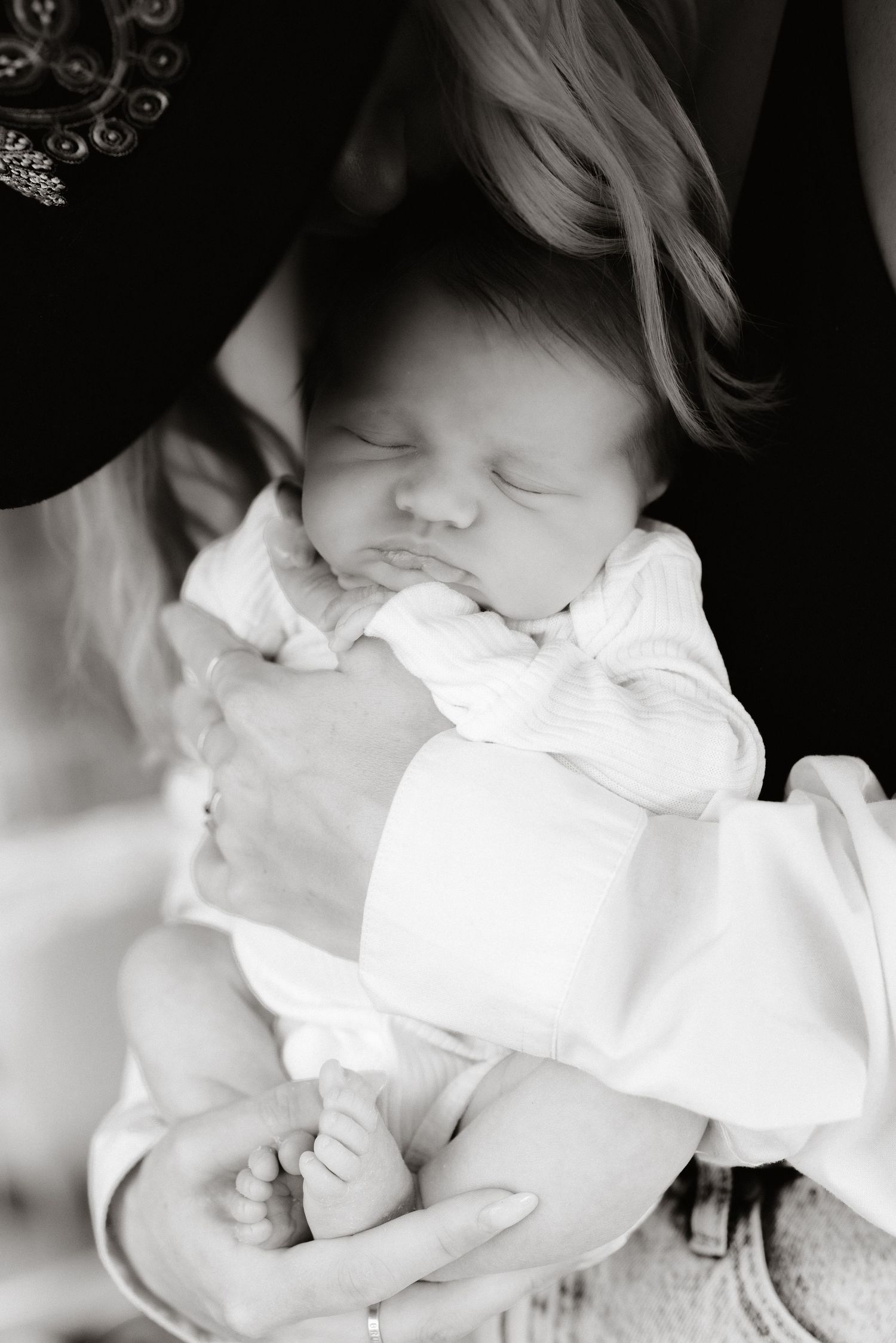 Ethereal black and white portrait of sleeping baby in white clothing.