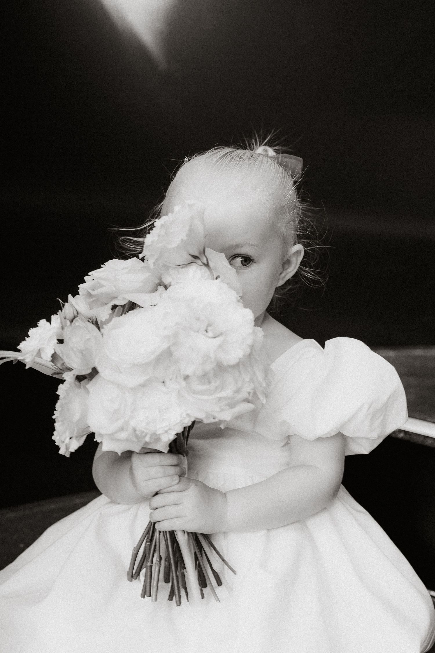 Black and white closeup of white rose wedding bouquet with delicate petals.