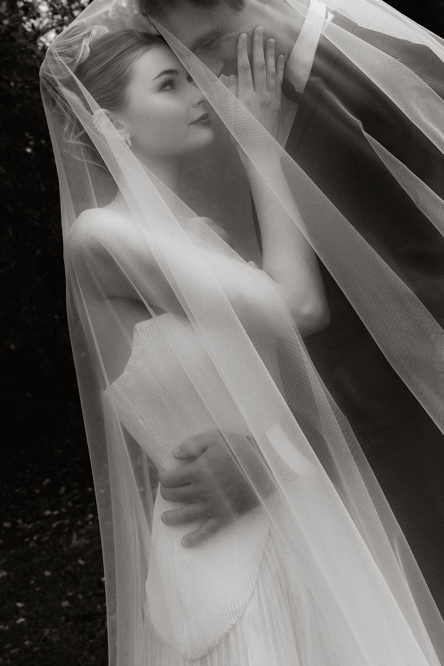 Artistic bridal photos feature flowing white veil creating ethereal silhouettes.