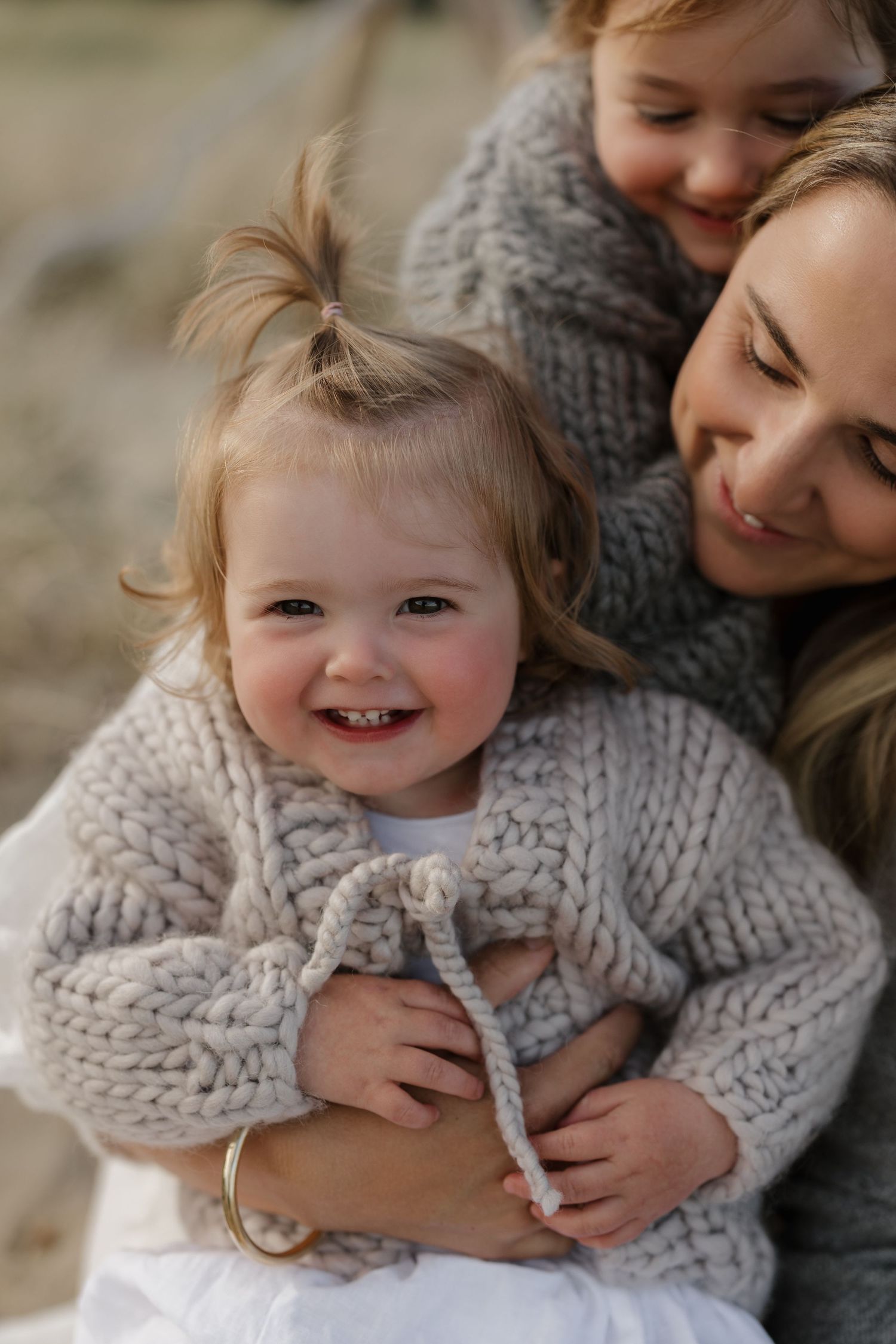 Close-up shots showing warm embraces and genuine smiles in matching knit sweaters.