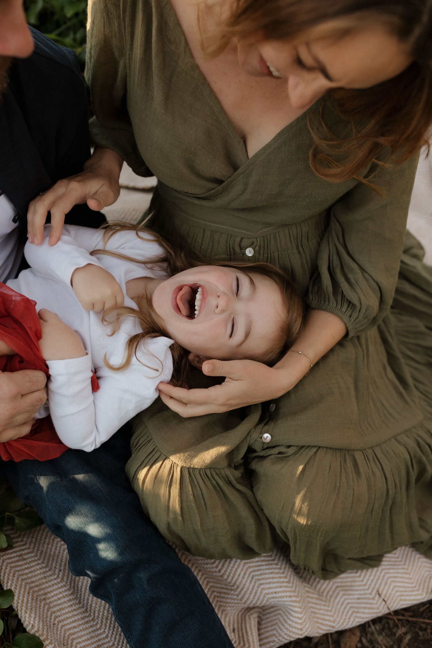 Candid moment of joyful laughter during family photoshoot.