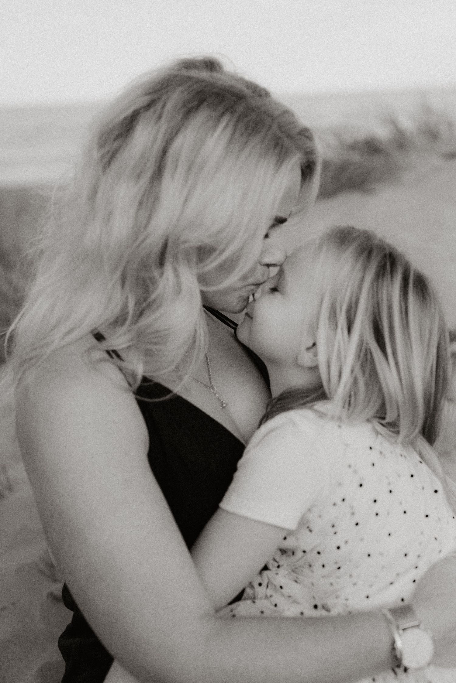 A tender embrace between mother and child shown in black and white.