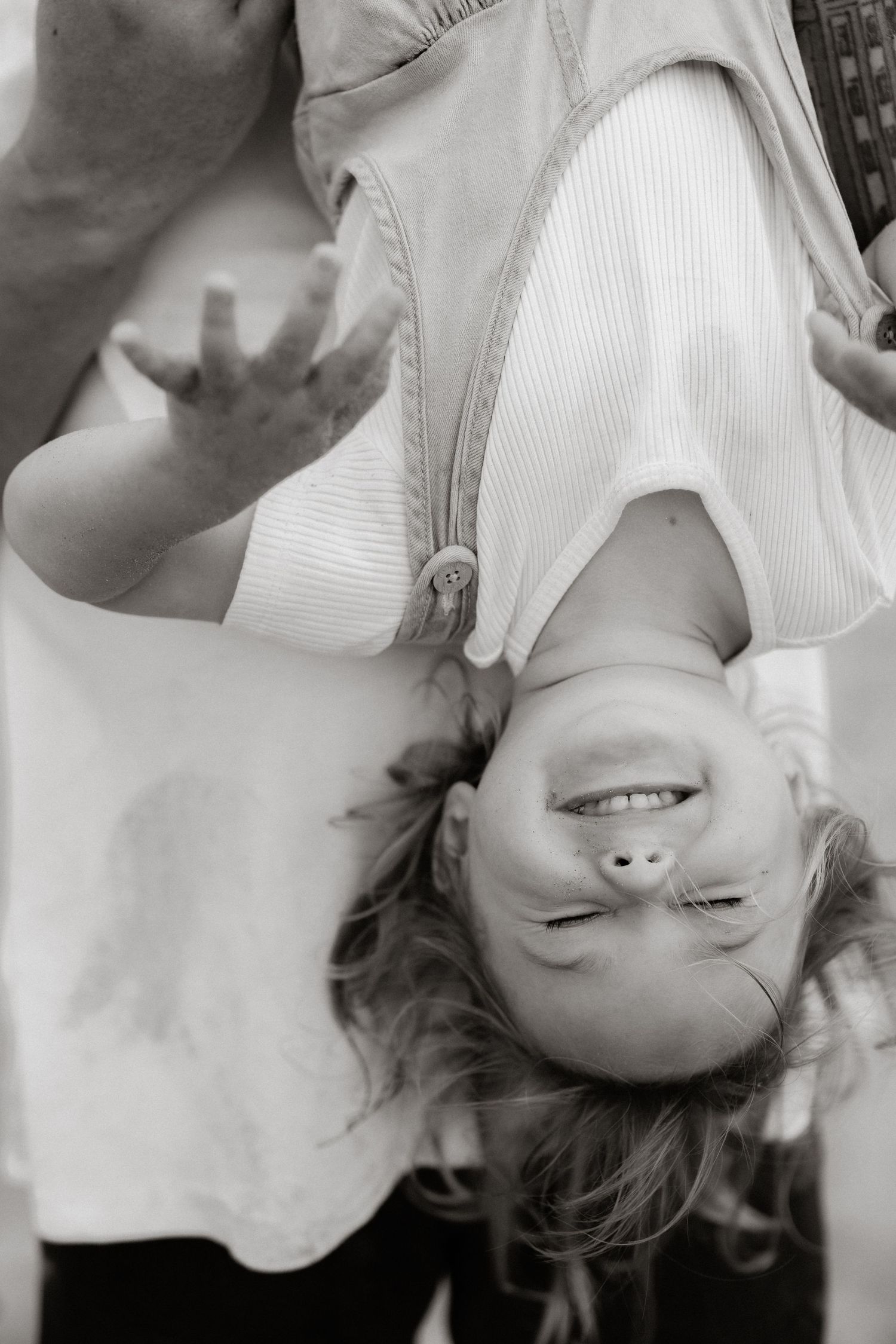 Black and white artistic portrait series showing person lying down with different playful expressions in each frame.