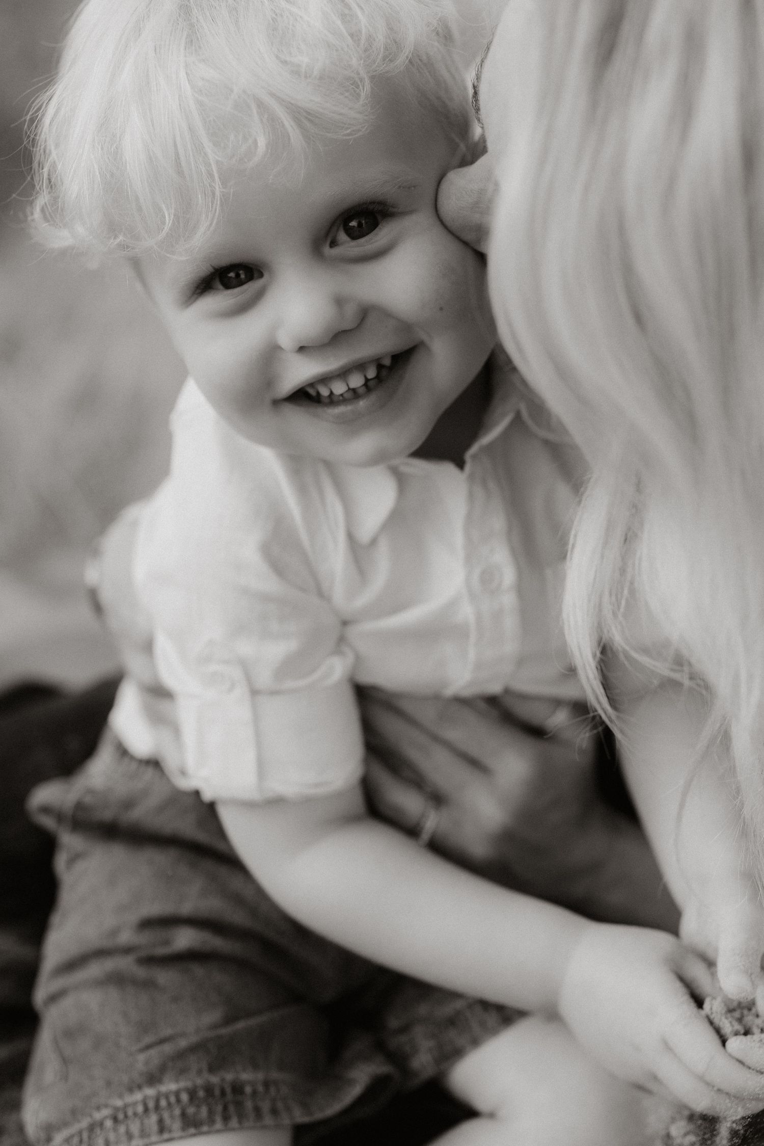 A series of black and white close-up portraits showing innocent childhood expressions and joyful laughter.