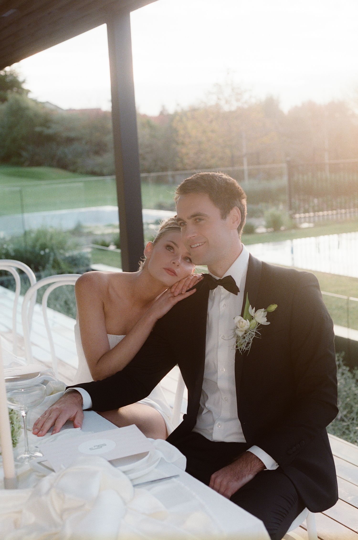 Romantic sunset moment captured on an outdoor terrace during a wedding reception.