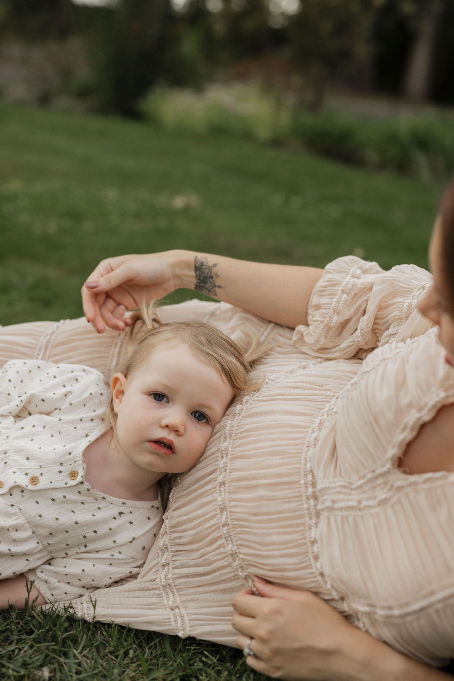 A peaceful outdoor portrait on grass with soft, vintage-inspired clothing.