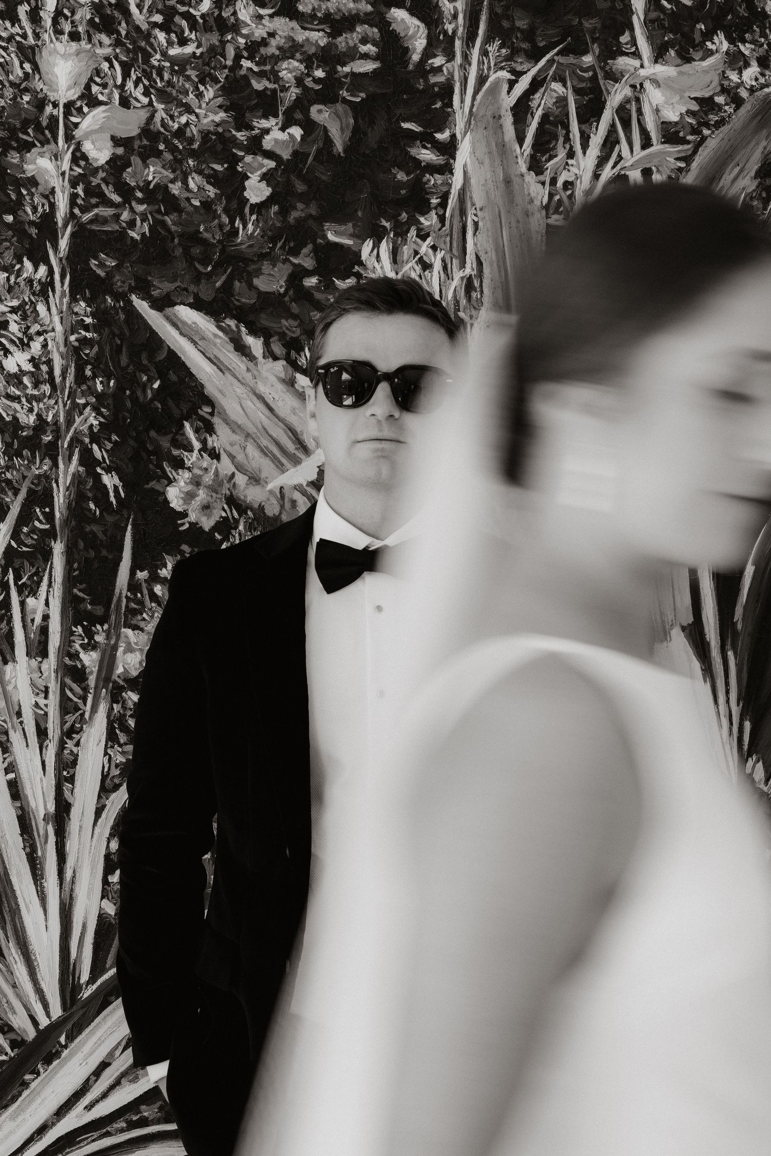 Artistic black and white wedding photography through foliage.