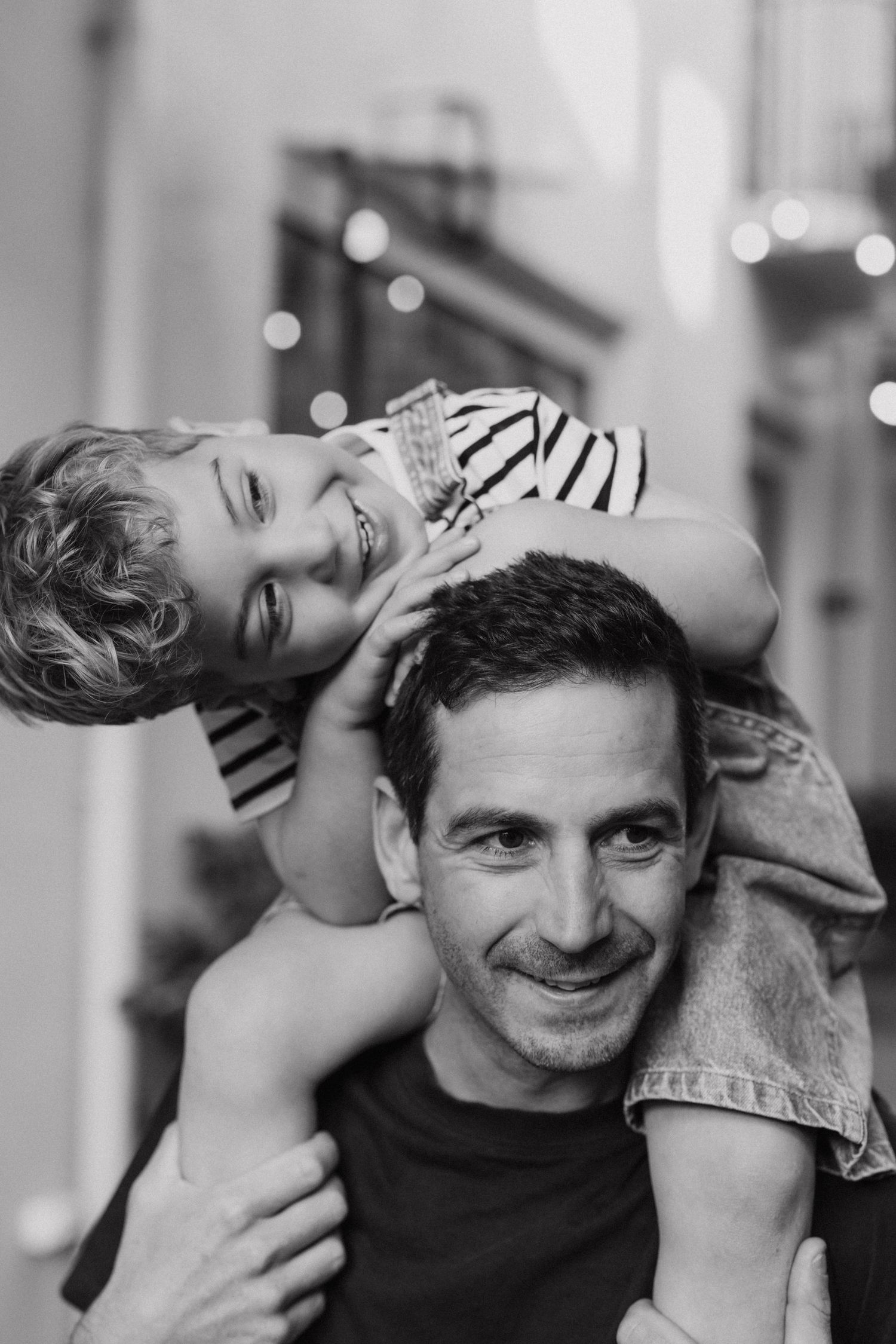 Black and white photo series showing a loving interaction between parent and child in candid playful moments.