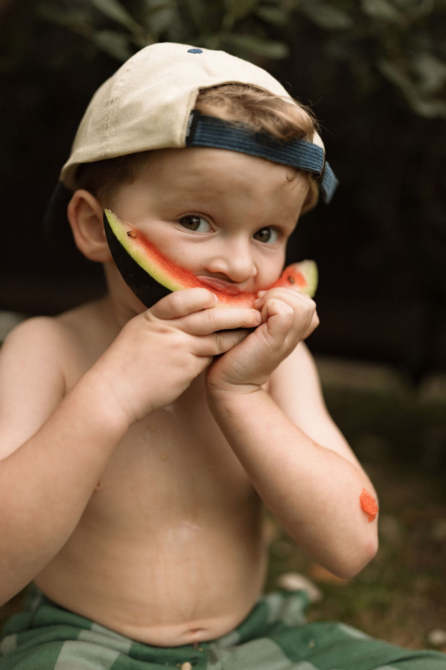 A series of sequential photos showing a child enjoying and taking a big bite of a juicy watermelon slice outdoors.