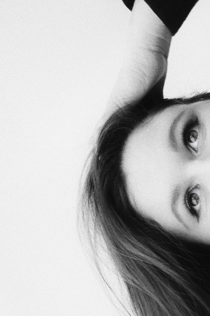 Black and white close-up portrait of a young woman with long hair gazing at the camera.