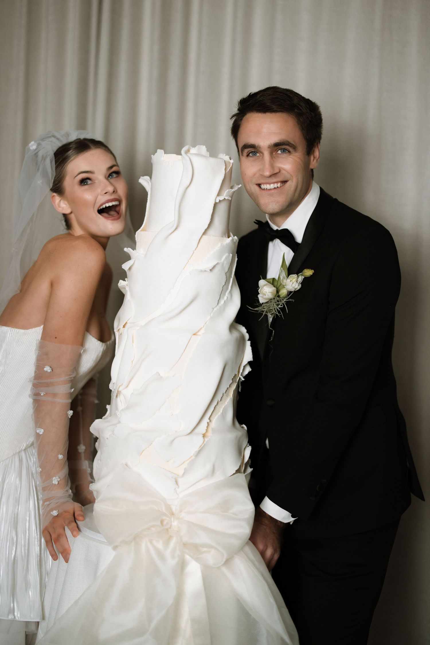 Four black and white wedding photos showing joyful moments between a bride in a white gown and groom in a black suit.