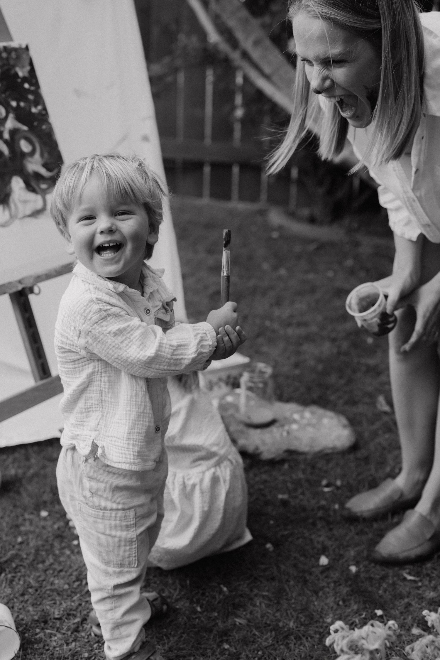 Candid black and white photos capturing joyful moments of play in a garden setting.