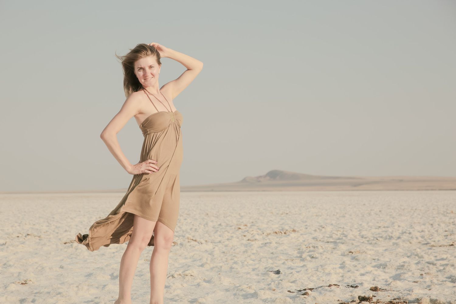 Artistic desert photoshoot featuring flowing fabric movement and natural lighting.