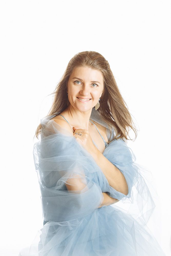 Romantic portrait series with flowing blue fabric and soft natural lighting.