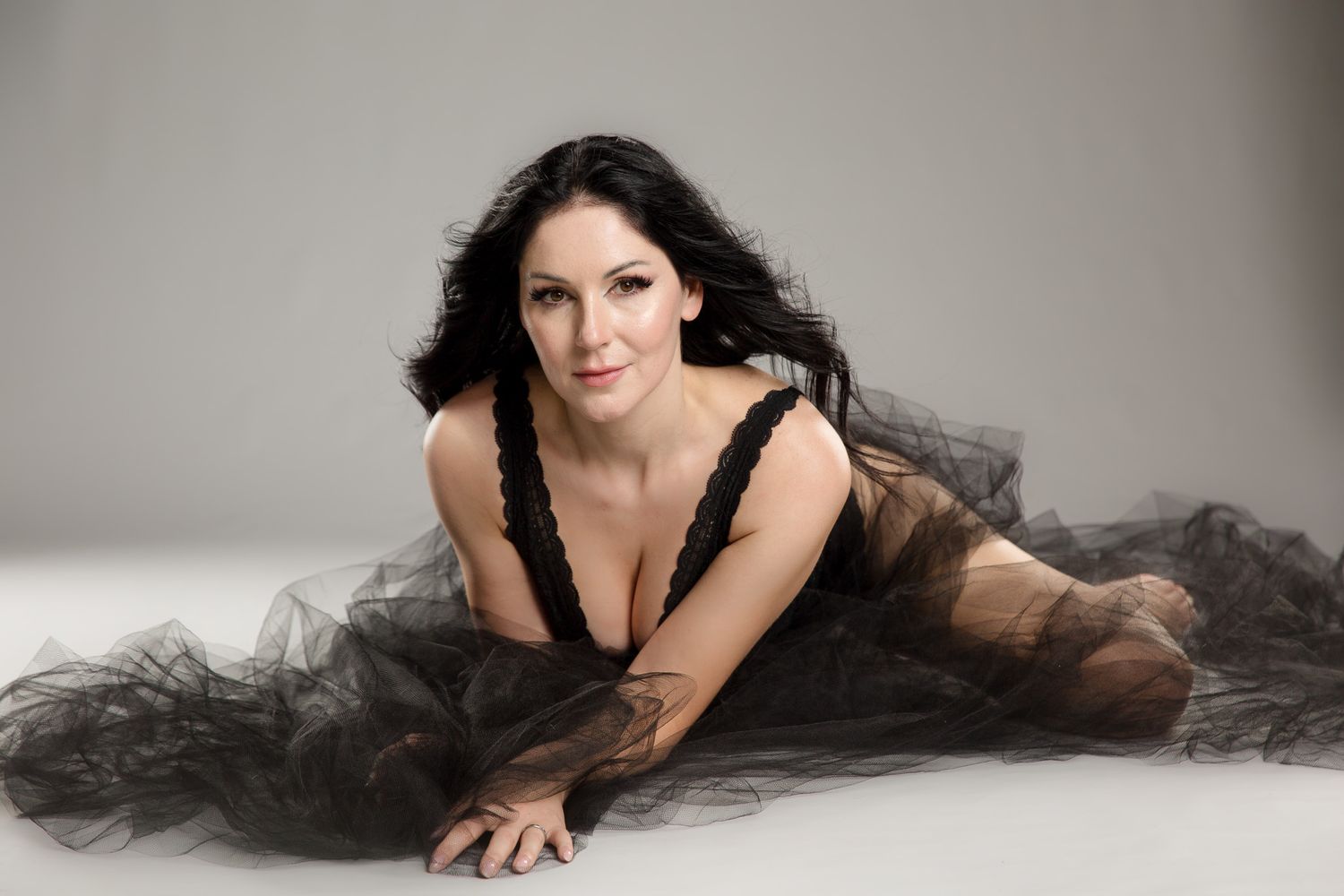 Dramatic portrait series with figure in black tulle dress against grey background.