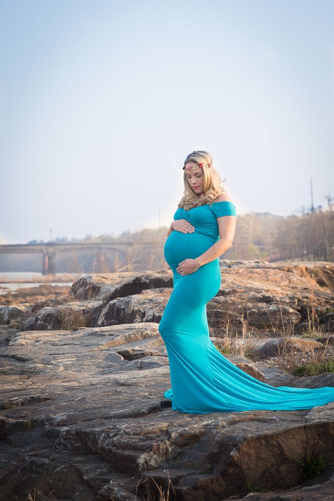 Flowing turquoise maternity gown photo session on rocky outcrop at sunset.
