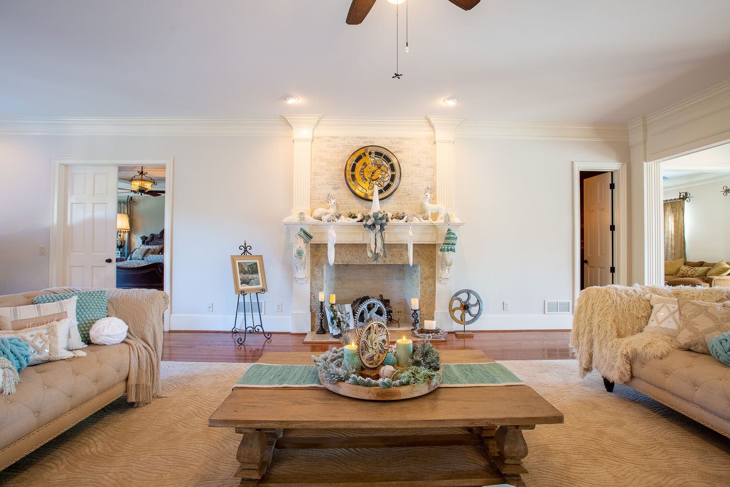 Neutral living room with beige sofas, rustic coffee table, and decorative fireplace mantel.