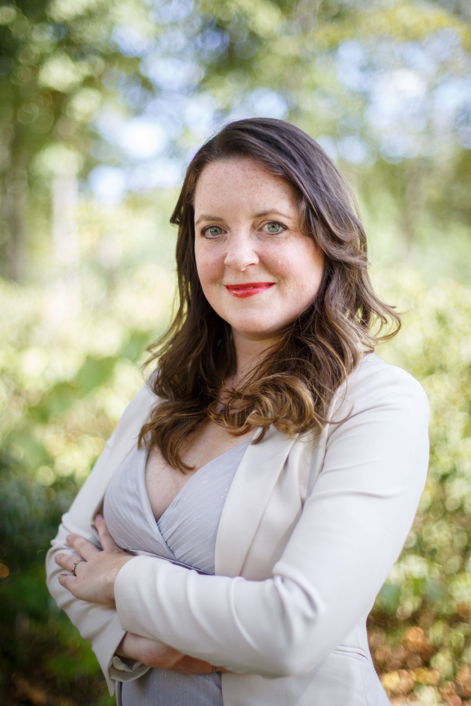 Professional outdoor portrait series in white blazer with natural bokeh background.