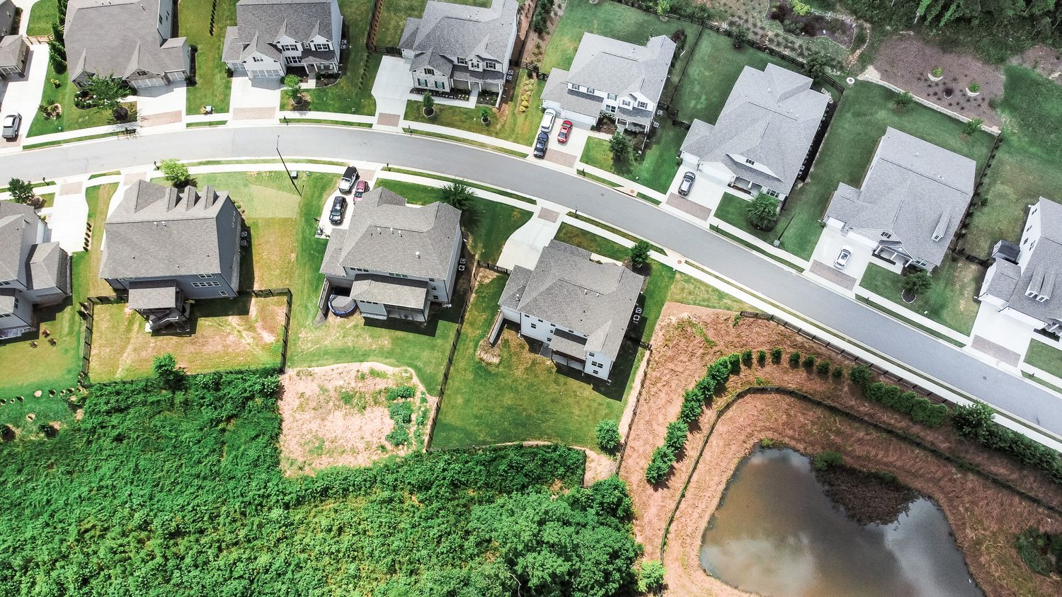 Bird's eye view of curved streets and residential homes in a new subdivision.